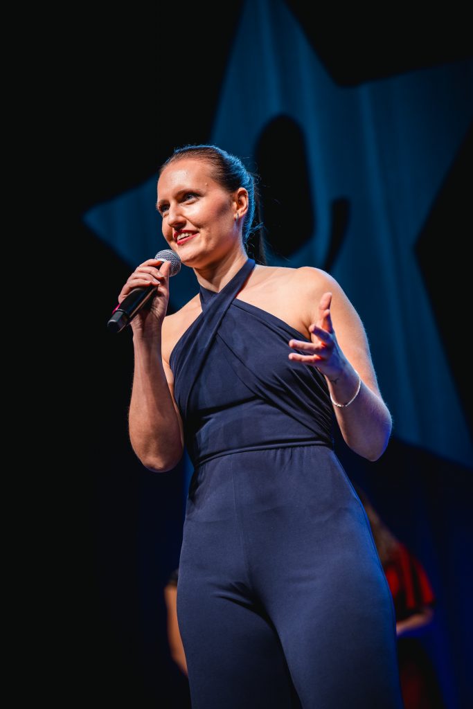 Viviane Albert auf der Bühne, Keynote-Speakerin für das kugelsichere Mindset, symbolisiert mentale Stärke und Wiedereinsatzbereitschaft
